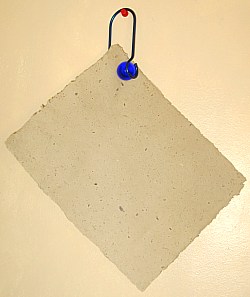 ball clip hanging on a pin holding homemade paper