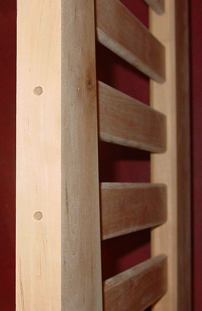 Through holes drilled through the bottom of the mortises allow me to glue in dowels after assembly to secure the unglued slats into place